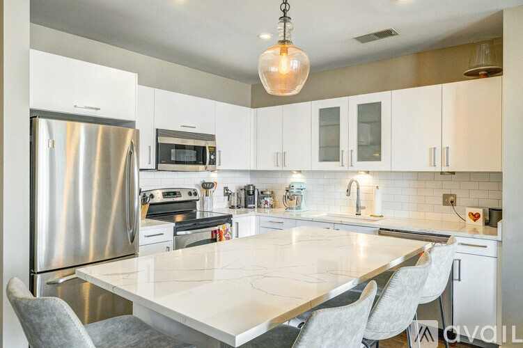 A kitchen with a white table and grey chairs.