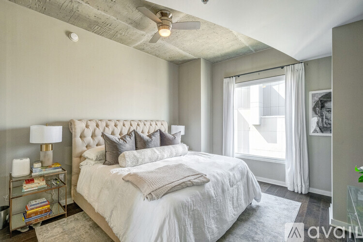 A well-lit bedroom with a large bed and a ceiling fan.