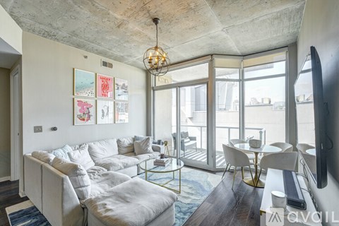 A living room with a white couch and a glass table.