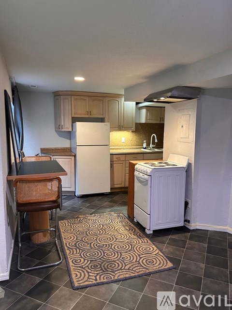 A kitchen with a white refrigerator and wooden cabinets.