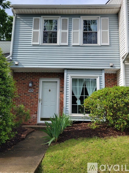 A house with a white door and windows with white shutters.