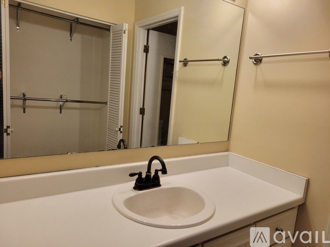 A white sink in a bathroom with a mirror above it.