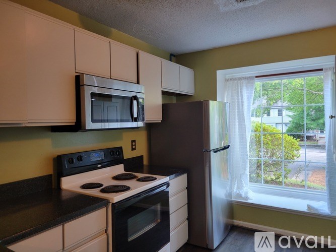 A kitchen with a black stove top oven and a white microwave above it.