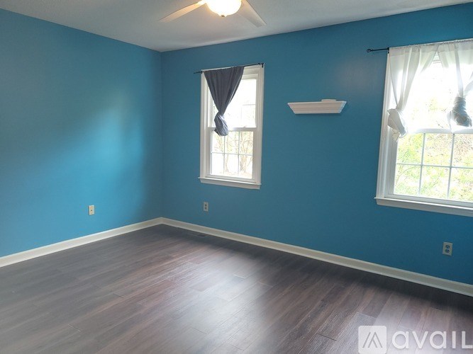 A room with blue walls and a window with white curtains.