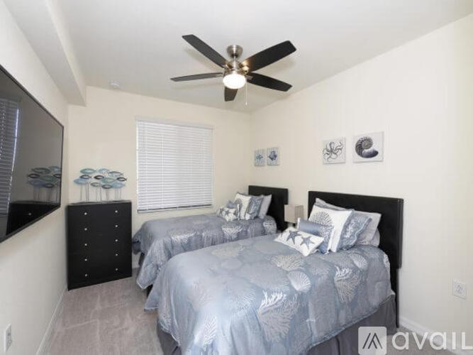 A bedroom with two beds and a ceiling fan.