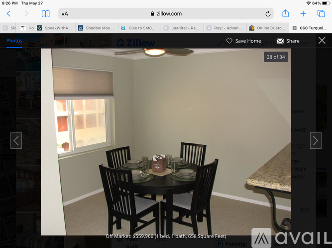 A dining room with a table set for four.