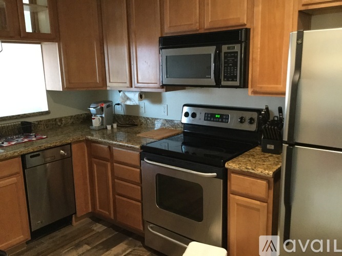 A kitchen with wooden cabinets and a black stove top oven.