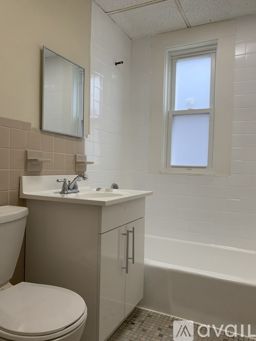 A white toilet sits next to a sink in a small bathroom.