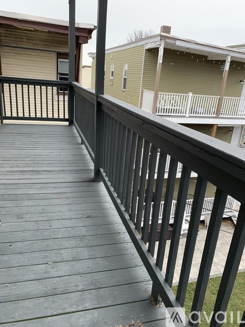 A wooden deck with a black railing.