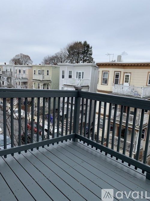 A balcony with a railing overlooking a row of houses.