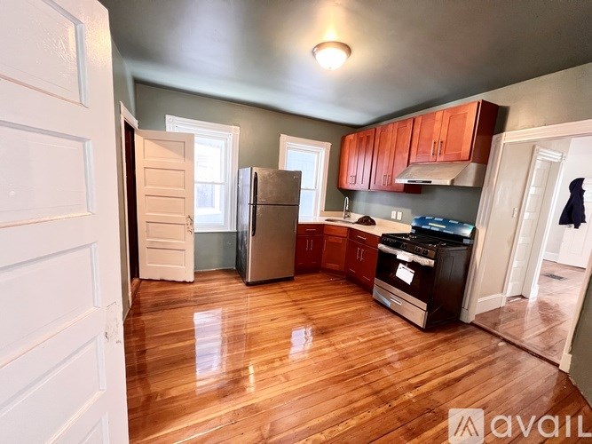 A kitchen with wooden floors and a refrigerator.