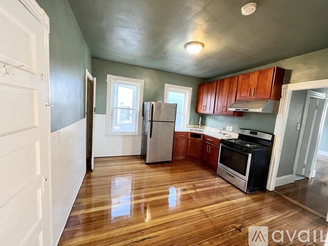 A kitchen with wooden floors and white walls.