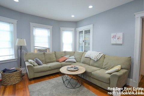 A living room with a grey couch and a coffee table.