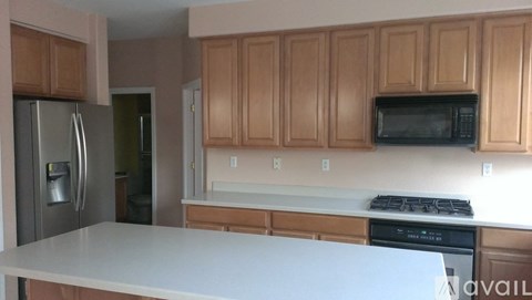 A kitchen with wooden cabinets and a white countertop.