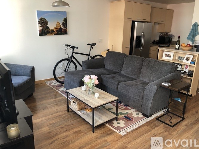 A living room with a grey couch, a coffee table, and a bicycle.