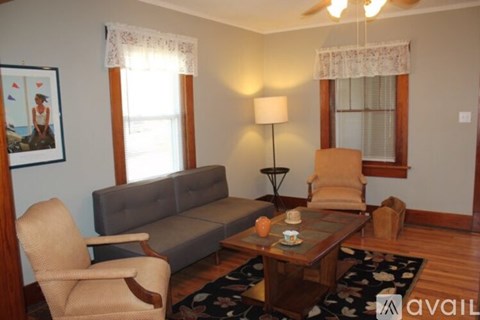 A living room with a grey couch, a wooden coffee table, and a painting on the wall.