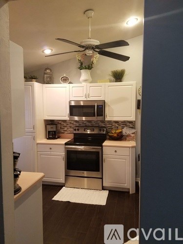 A kitchen with white cabinets and a black stove top oven.