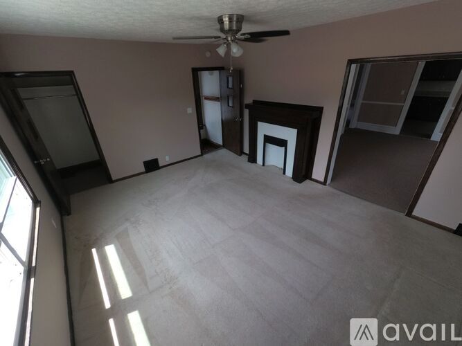 A room with a ceiling fan and a large window.