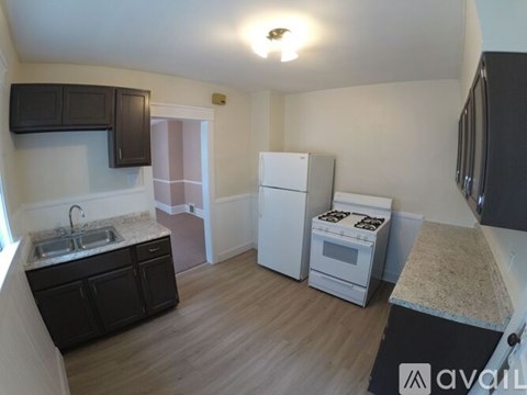A kitchen with a sink, stove, and refrigerator.