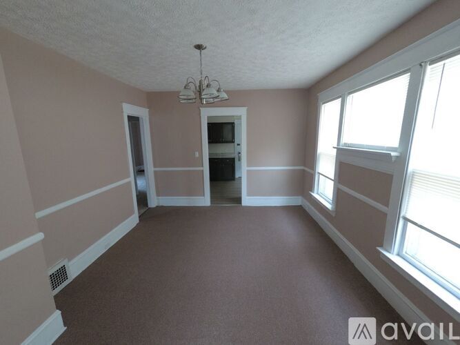 A room with a chandelier and a window.