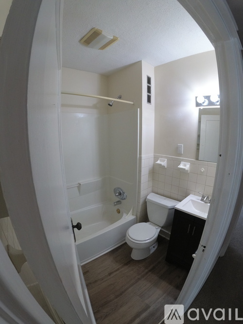 A bathroom with a toilet, sink, and bathtub.