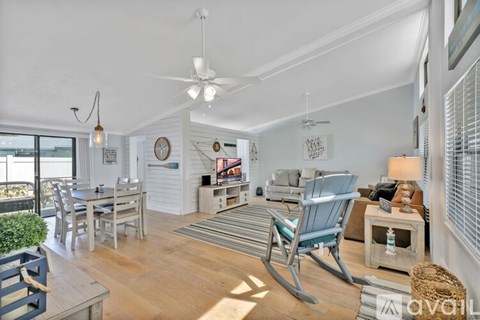 A living room with a rocking chair and a dining table.