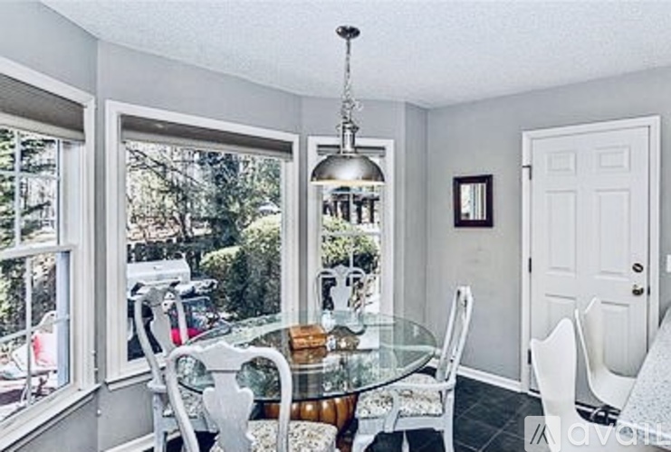 A dining room with a glass table and chairs.