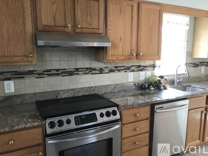 A kitchen with wooden cabinets and a black stove top oven.