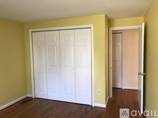 A white door is in a yellow room.