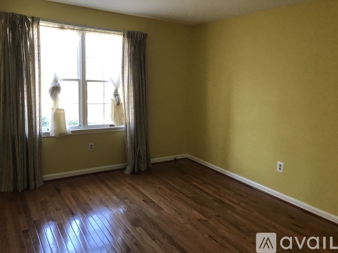 A room with a window and curtains.