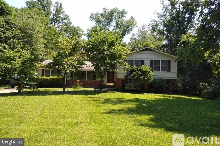 A house with a lawn and trees in front of it.