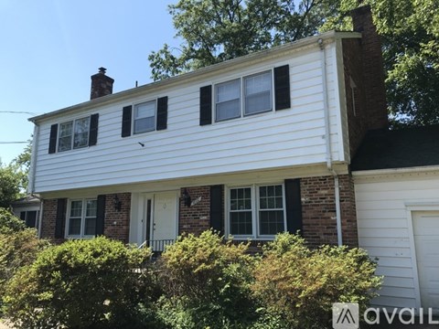A house with a white siding and a brick chimney.