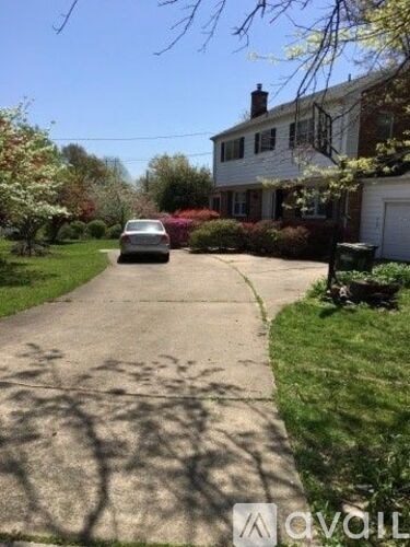 A car is parked on a driveway in front of a house.