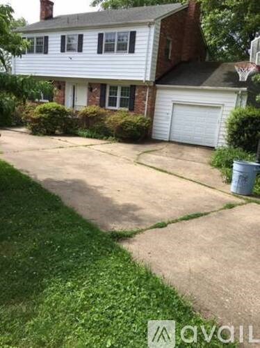 A white house with a driveway in front.