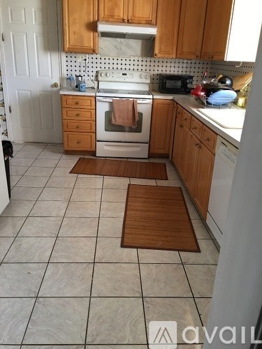 A kitchen with wooden cabinets and a white oven.