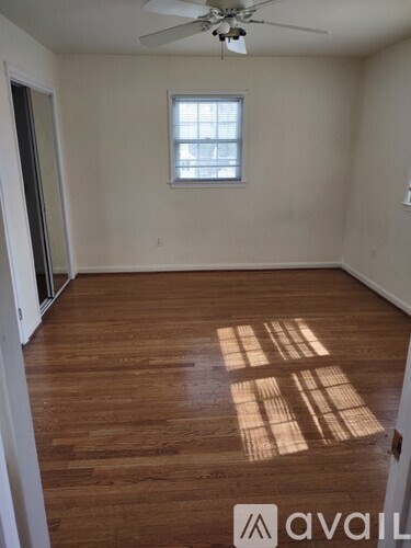 A room with wooden floors and a ceiling fan.