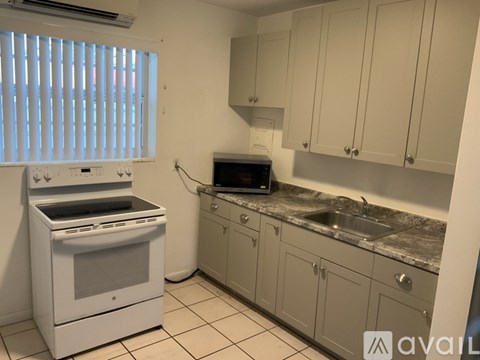 A kitchen with a white oven and cabinets.