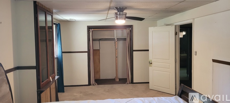 A room with a window and a black speaker on the floor.