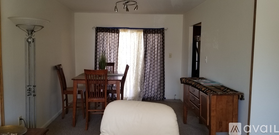 A bedroom with a bed, dresser, and chair.