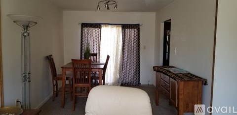 A bedroom with a bed, dresser, and chair.