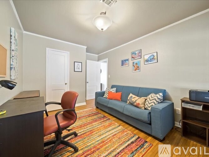 A living room with a blue couch and a red chair.