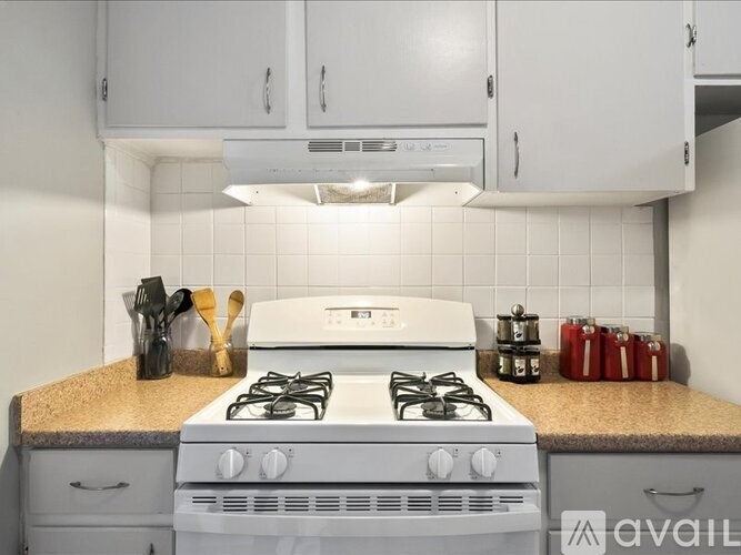A white stove top oven with a white range hood above it.