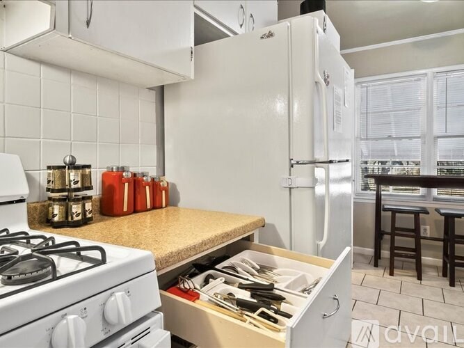 A kitchen with a white stove and a white refrigerator.