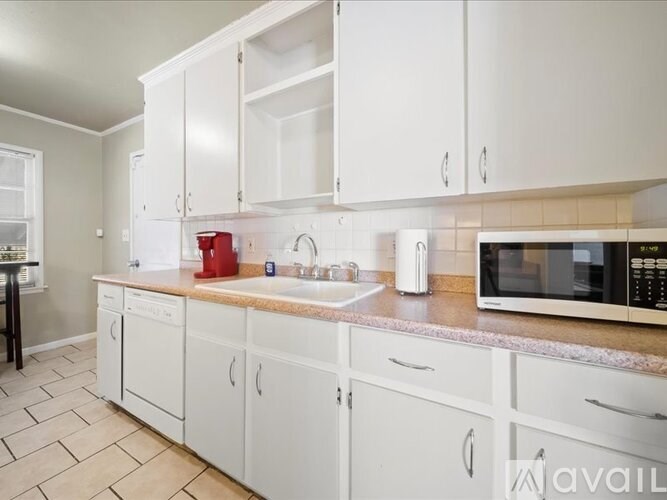 A kitchen with white cabinets and a granite countertop.