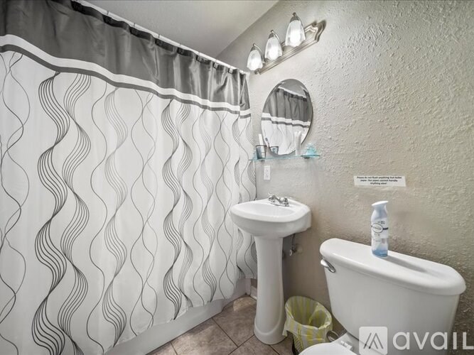 A bathroom with a white sink and a white toilet.