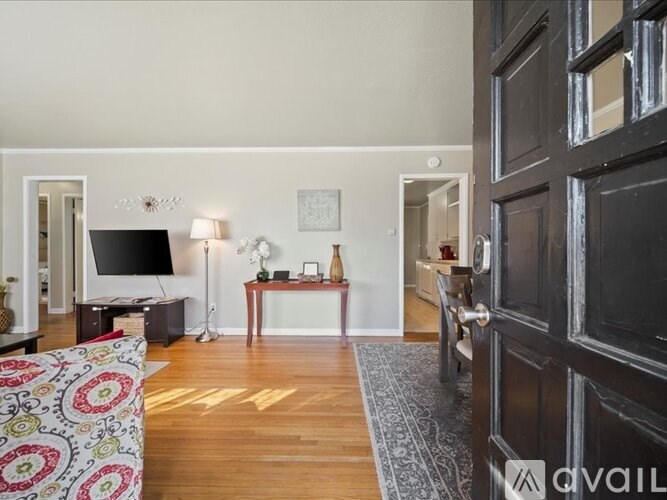 A living room with a couch, a television, and a lamp.