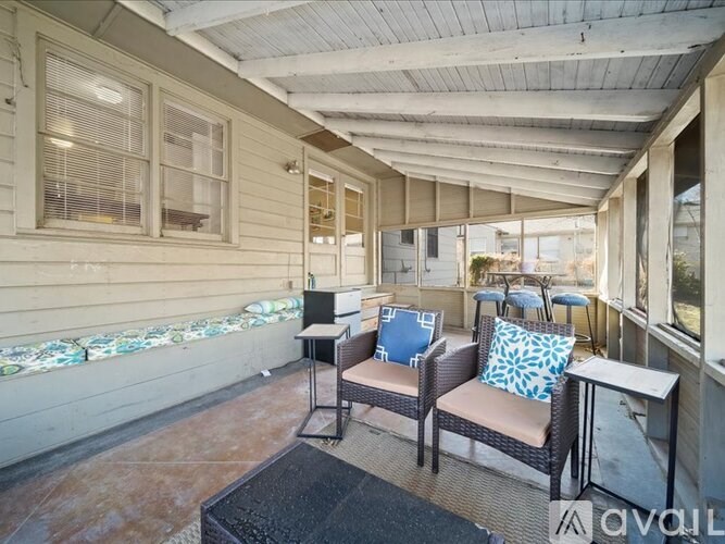 A patio with a couch, chairs, and a table.