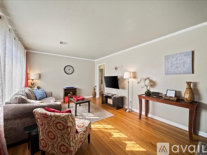 A living room with a couch, chair, and television.
