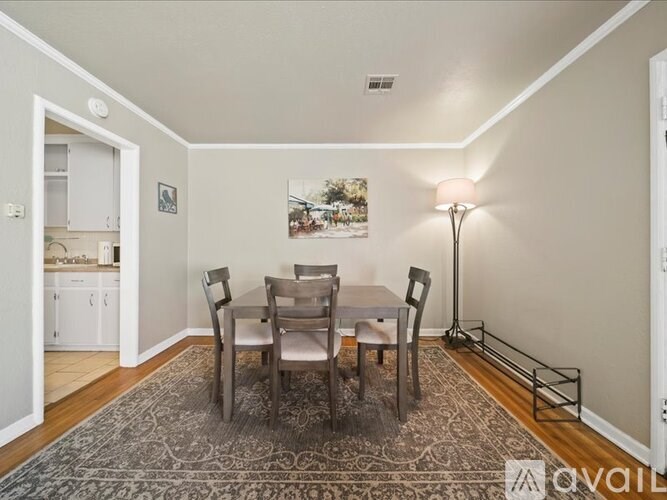 A dining room with a table and chairs.