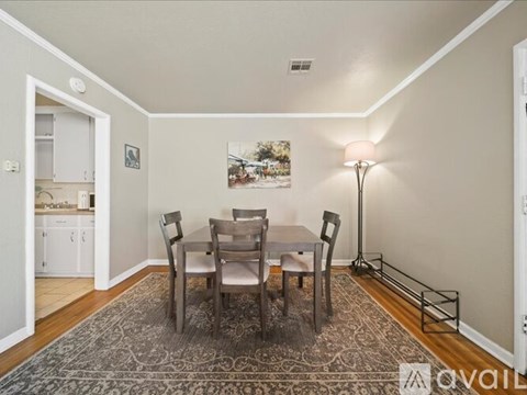 A dining room with a table and chairs.